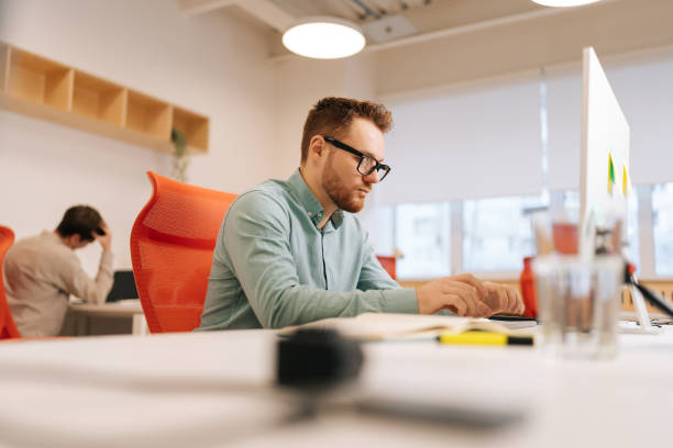 istock Low-angle view of focused businessman professional marketing manager using desktop computer. Successful businessman working on computer digital data management 2151960549