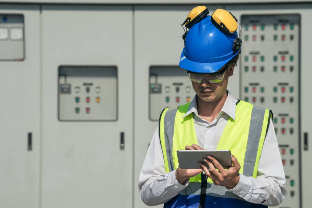 istock Focused young technician in safety gear inspects and controls industrial electrical equipment on a modern facility’s technical room. 2151960876