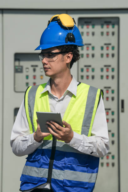 istock Focused young technician in safety gear inspects and controls industrial electrical equipment on a modern facility’s technical room. 2151961598
