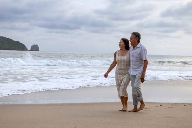 istock Mature couple holding hands and spending time on the beach 2151961648