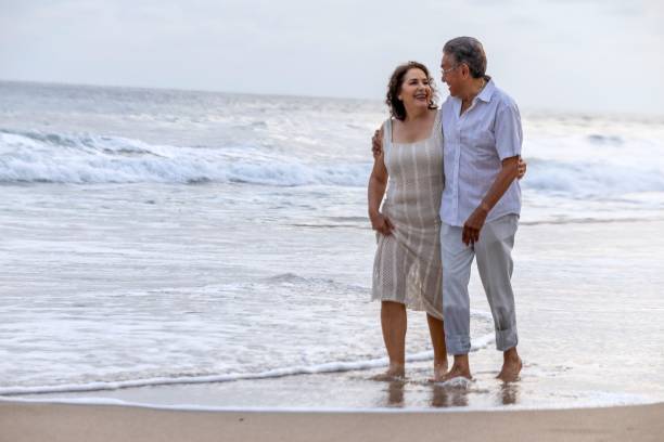 istock Mature couple holding hands and spending time on the beach 2151961658