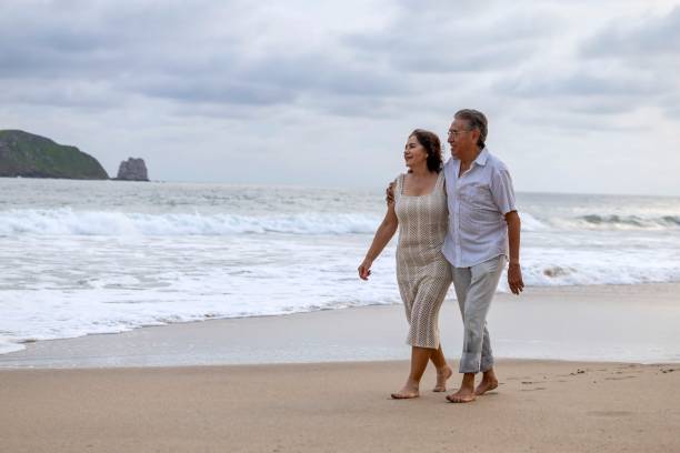 istock Mature couple holding hands and spending time on the beach 2151961678