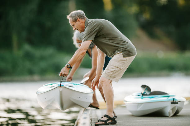 istock Active senior couple placing kayak in river from dock 2151962134