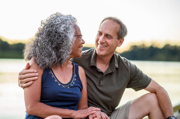 Affectionate and active senior couple enjoying sunset along a river