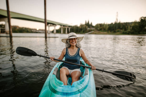Smiling Pacific Islander senior woman kayaking