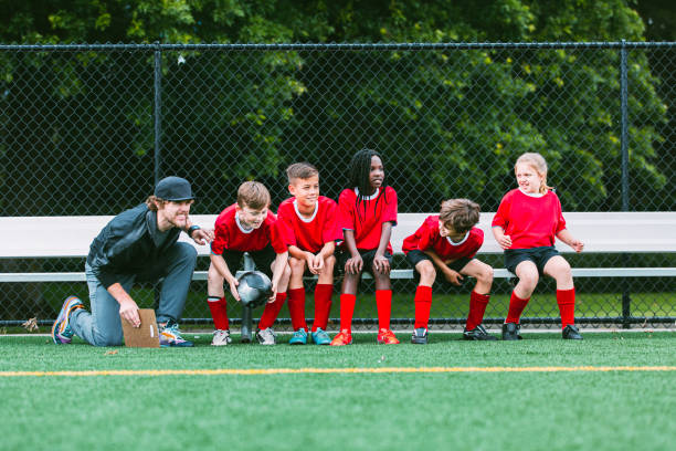 istock Coach and young soccer plays sit on bench in anticipation 2151963145