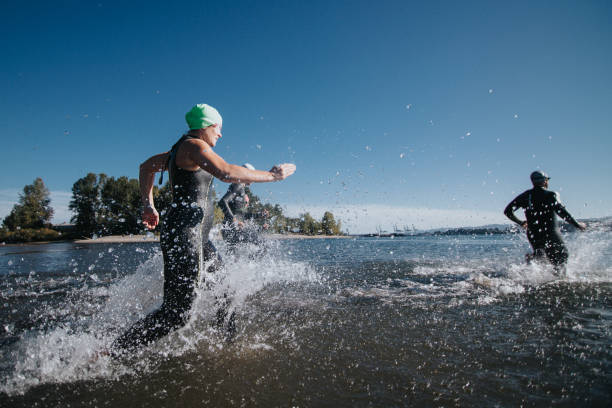Woman, man and running for fitness, street and endurance in summer for wellness, challenge and exercise. People, personal trainer and coach for cardio, workout and training for marathon in city
