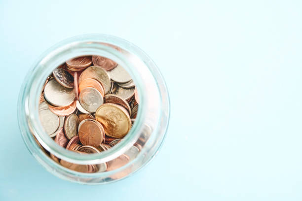 American currency in a jar on a blue background with space for text