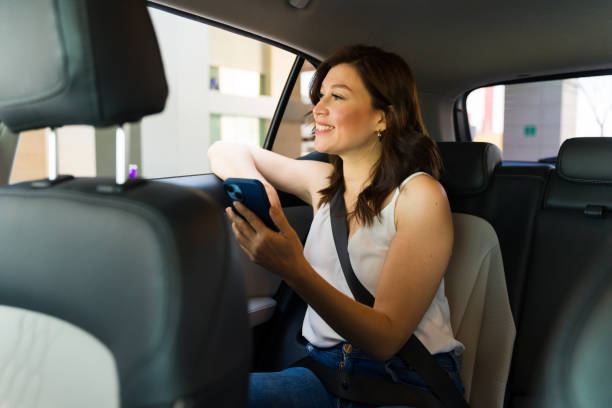 istock Happy woman enjoying the view from the car window while using her smartphone on a relaxing drive 2151968974