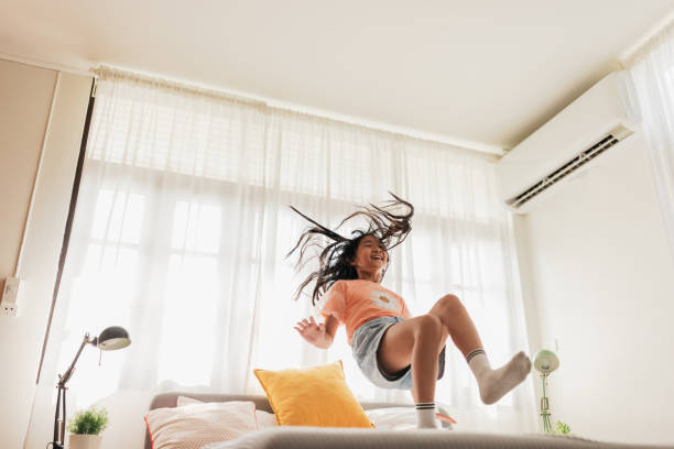 istock Girl jumping on the bed 2151973820