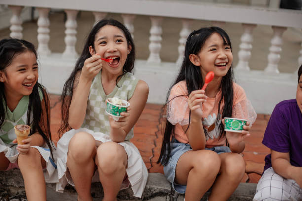 A group of kids is eating ice cream outdoors.