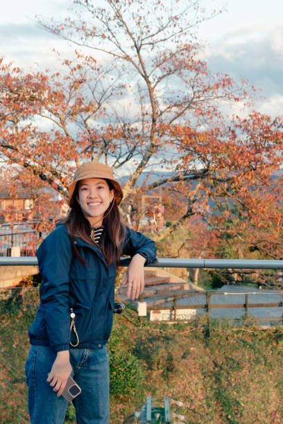 GenZ tourist modern travel japan using digital devices connection technology uploading images to her friend at tourist spot at the top of amanohashidate viewpoint Japan
