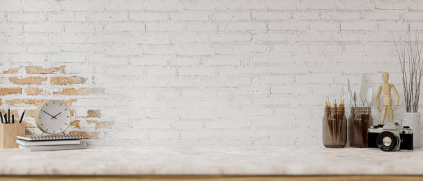 istock A white marble tabletop features painting tools and a space against the white brick wall. 2151978184