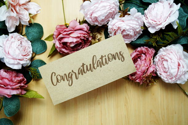 istock Congratulations text message on paper card with flowers border frame on wooden background 2151986255
