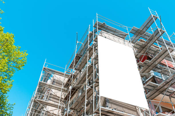 istock Blank white mockup advertisement hanging on the modern building under construction. Reconstruction of a building with white billboard. 2151987744