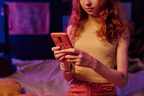 istock Red-haired Girl Browsing Web Sites On Smartphone 2151988167