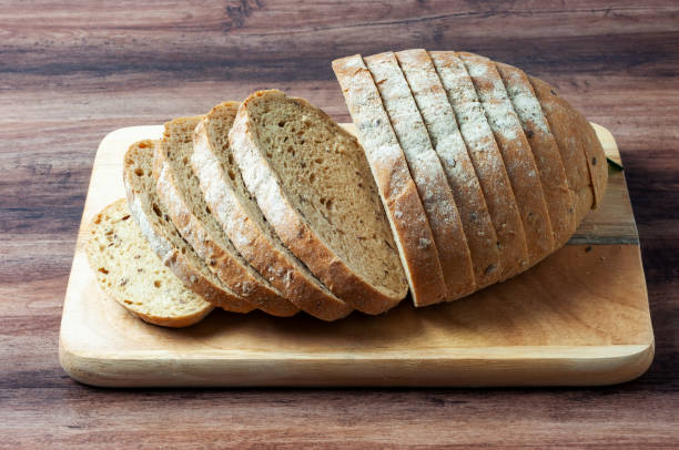 istock Loaf of multigrain bread on a wood tray 2151988871