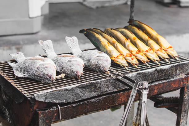 Catfish is grilled on skewers over coals.