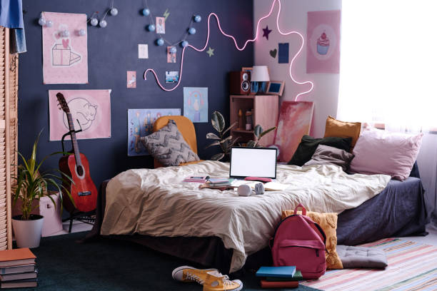 Modern Teenagers Room Interior No people wide shot of modern teenagers bedroom interior with laptop on bed, posters and lights on walls, copy space neon bedroom stock pictures, royalty-free photos & images
