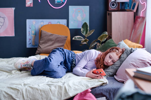 istock Sleepy Girl Watching Videos On Smartphone 2151990207