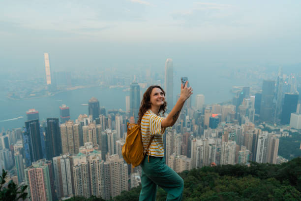 istock Woman using smartphone on viewpoint overlooking Hong Kong cityscape 2151990302
