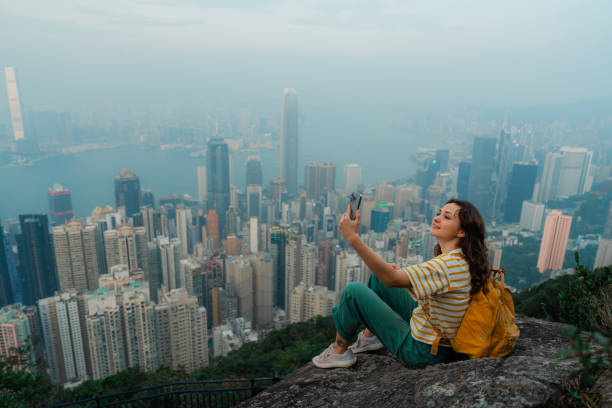 istock Woman using smartphone on viewpoint overlooking Hong Kong cityscape 2151990309