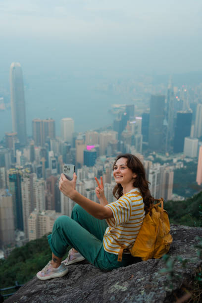 istock Woman using smartphone on viewpoint overlooking Hong Kong cityscape 2151990339