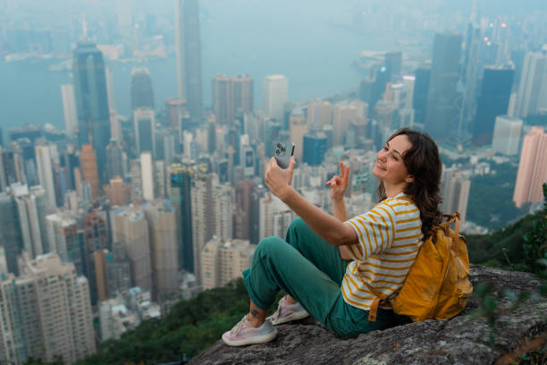 istock Woman using smartphone on viewpoint overlooking Hong Kong cityscape 2151990341