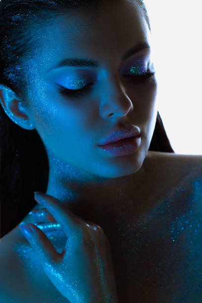 istock Womans profile glows with sparkling skin, highlighted by blue tones makeup, exuding a calm and mystical aura 2151990874