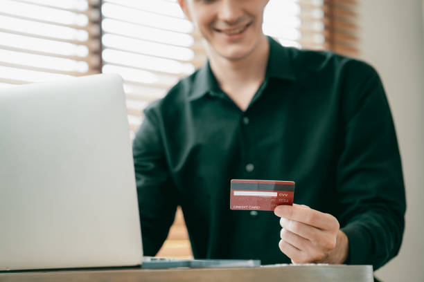 istock Young man using laptop with credit card for internet banking. Unveiling 2151993070