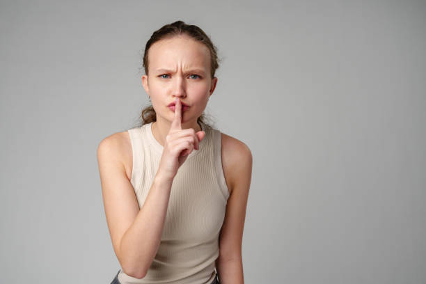 istock Young Woman Making a Hush Gesture on gray background in studio 2151993319