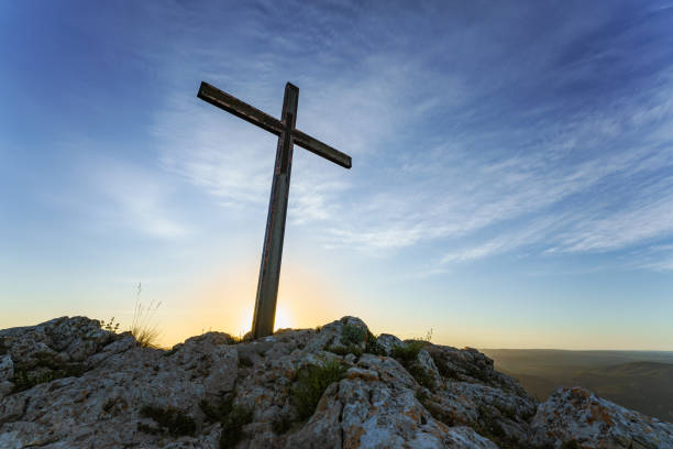 istock Christian Cross Atop Rocky Hill Against Sunset Sky 2151994695