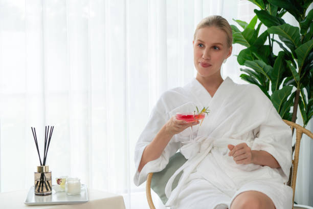 istock Couple wearing bathrobe relaxing with drinks in luxurious hotel spa. Quiescent 2151995212