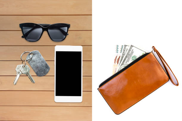 Cash in brown wallet isolate on white background, sunglasses and smartphone with house key on wooden table Cash in brown wallet isolate on white background, sunglasses and smartphone with house key on wooden table, finanacial and life style concept phone wallet keys stock pictures, royalty-free photos & images