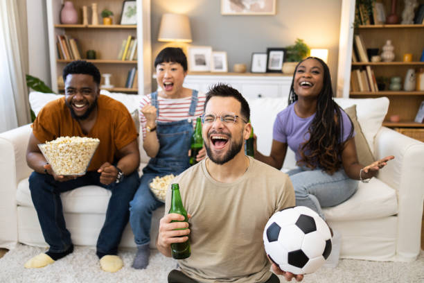 istock Group of ecstatic friends cheering for their team 2151999374