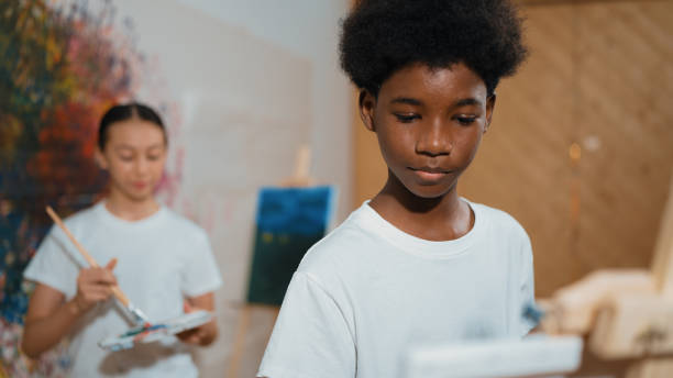 istock Diverse children painting canvas together in creative art lesson. Edification. 2152000310