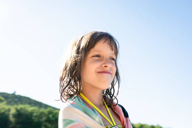 Happy girl at the beach standing and looking away