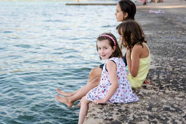 istock Children sitting by the sea 2152002621