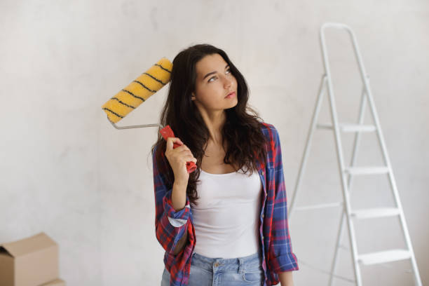 istock Thinking Painter Woman Portrait With Paint Roller Before Renovation 2152003287