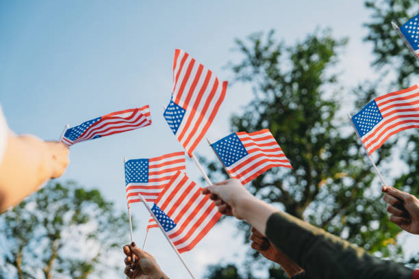 istock A group of people is waving small American flags at sunset 2152004108