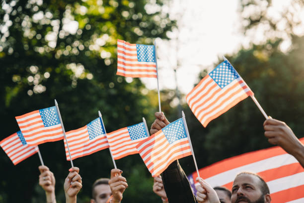istock A group of people is waving small American flags at sunset 2152004124