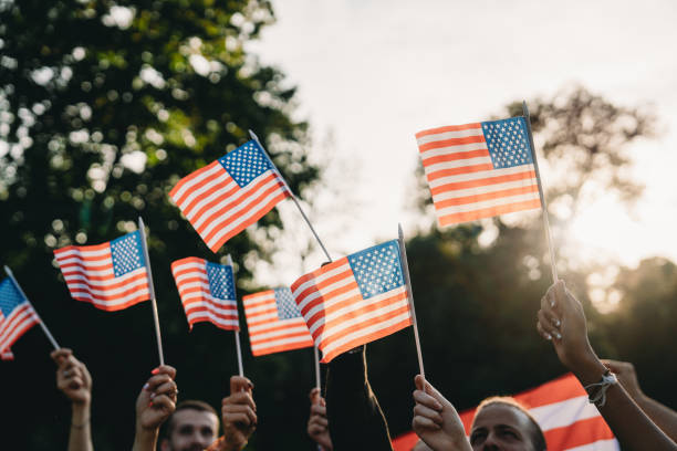 istock A group of people is waving small American flags at sunset 2152004128