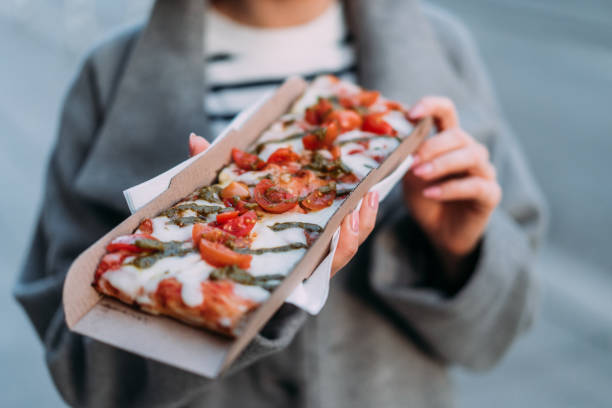 istock Woman eating pizza on the street. 2152006421