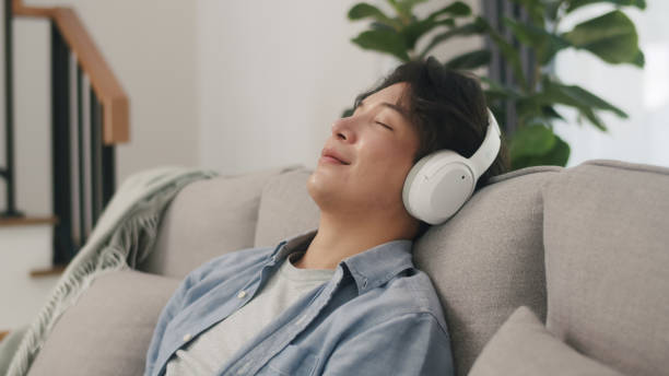 istock Man Relaxes with Music on Comfortable Sofa. 2152007055