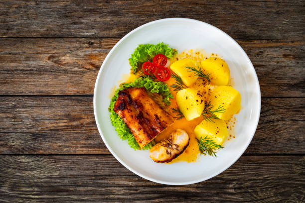 istock Baked rabbit saddle, boiled potatoes and vegetable salad on wooden table 2152007071