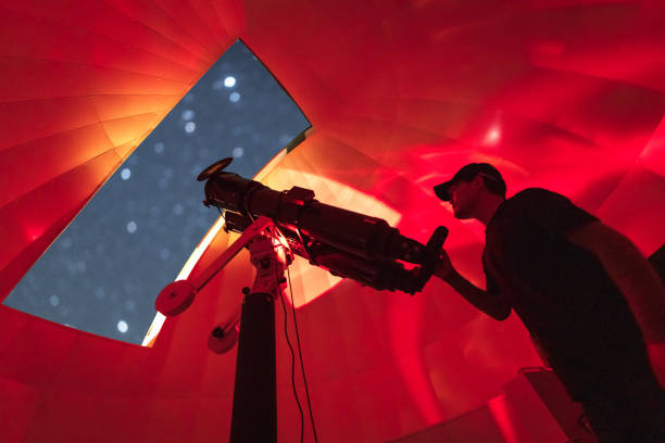 istock Astronomer in photo telescope dome with red light checking settings 2152007257