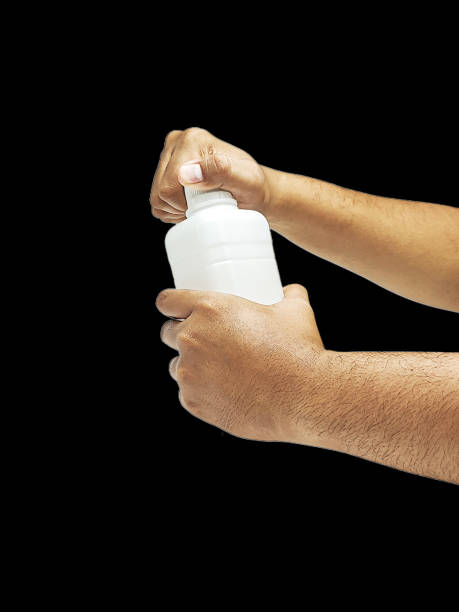 istock Asian man's hand opens a plastic bottle isolated on a black background. 2152012649