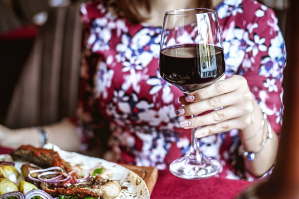 istock Woman Enjoying a Meal With Wine at a Table 2152015023