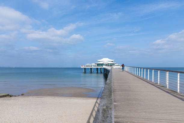 Timmendorfer Strand, Germany – March 13, 2024:  Pwerspective view of  Seeschlöesschenbrücke pier on a sunny day.