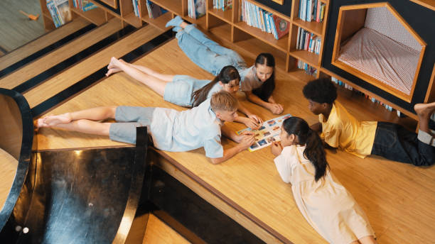 istock Group of children lying down in a circle while reading a book. Edification. 2152019147